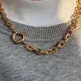 Gold plated chunky chain necklace with a bold front clasp detail.