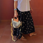 Close-up of basket bag with soft brown upcycled leather handles.
