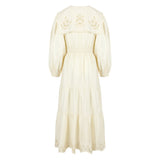 Side view of a lightweight cotton summer dress showing balloon sleeves and embroidered detailing on the bodice.