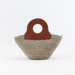 Handwoven basket bag featuring sturdy upcycled leather handles.