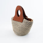 Basket bag with spacious interior and upcycled leather straps.