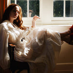 Model twirling in a tiered cotton summer dress with oversized collar and airy movement.