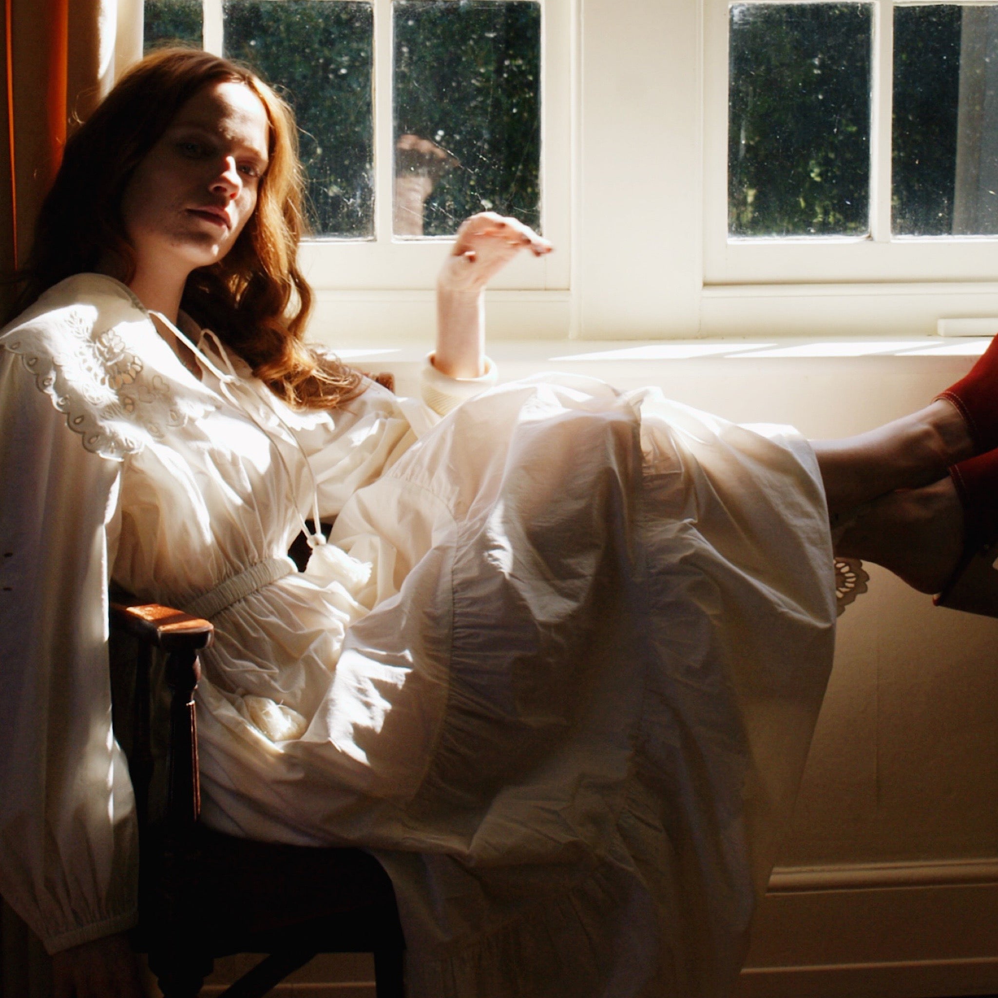 Model twirling in a tiered cotton summer dress with oversized collar and airy movement.