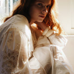 Seated pose showing embroidery details and the cinched waistline of the maxi summer dress.