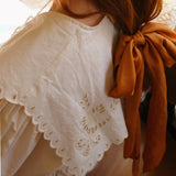 Natural lighting emphasizes the softness of a lightweight cotton maxi dress with tiered skirt and balloon sleeves.