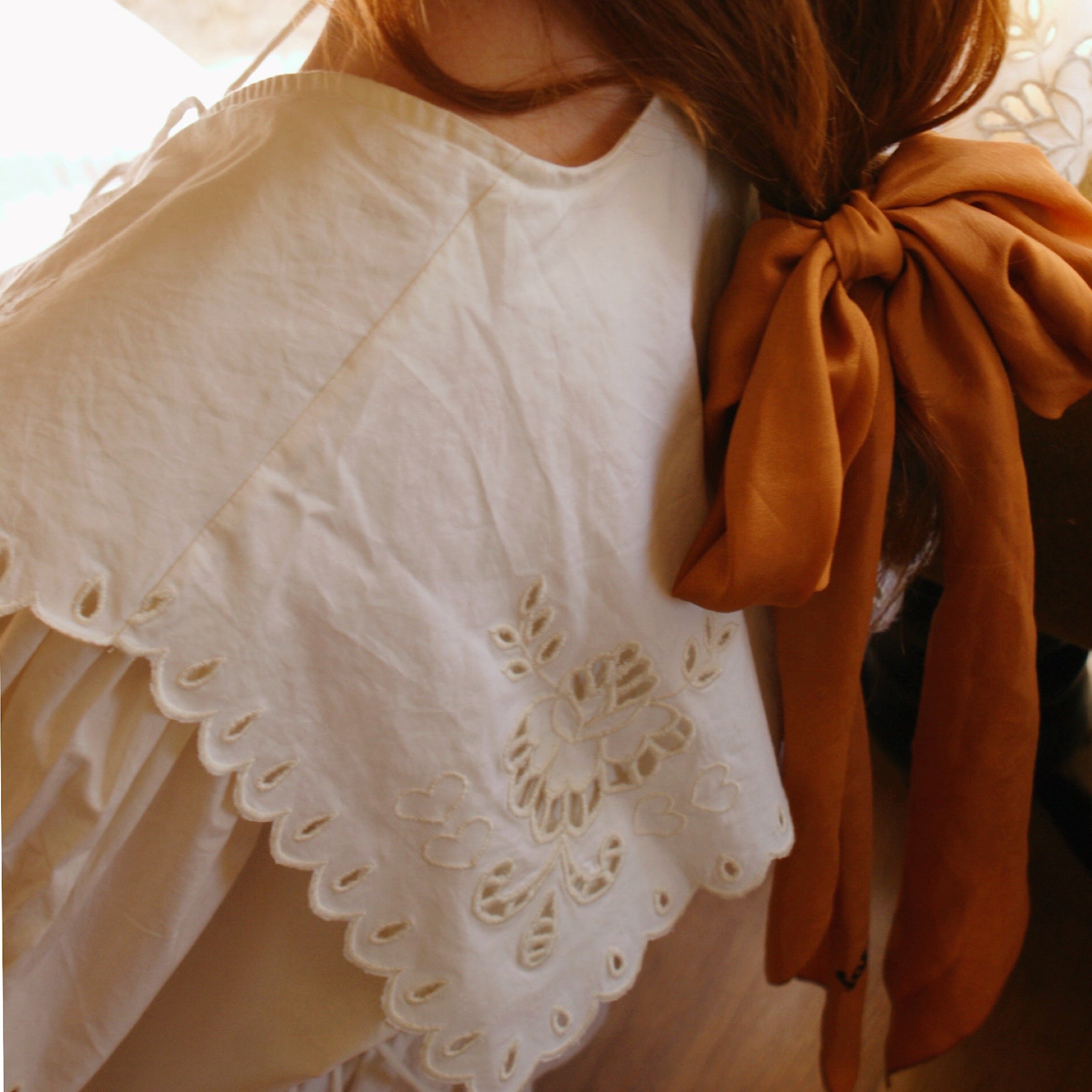 Natural lighting emphasizes the softness of a lightweight cotton maxi dress with tiered skirt and balloon sleeves.