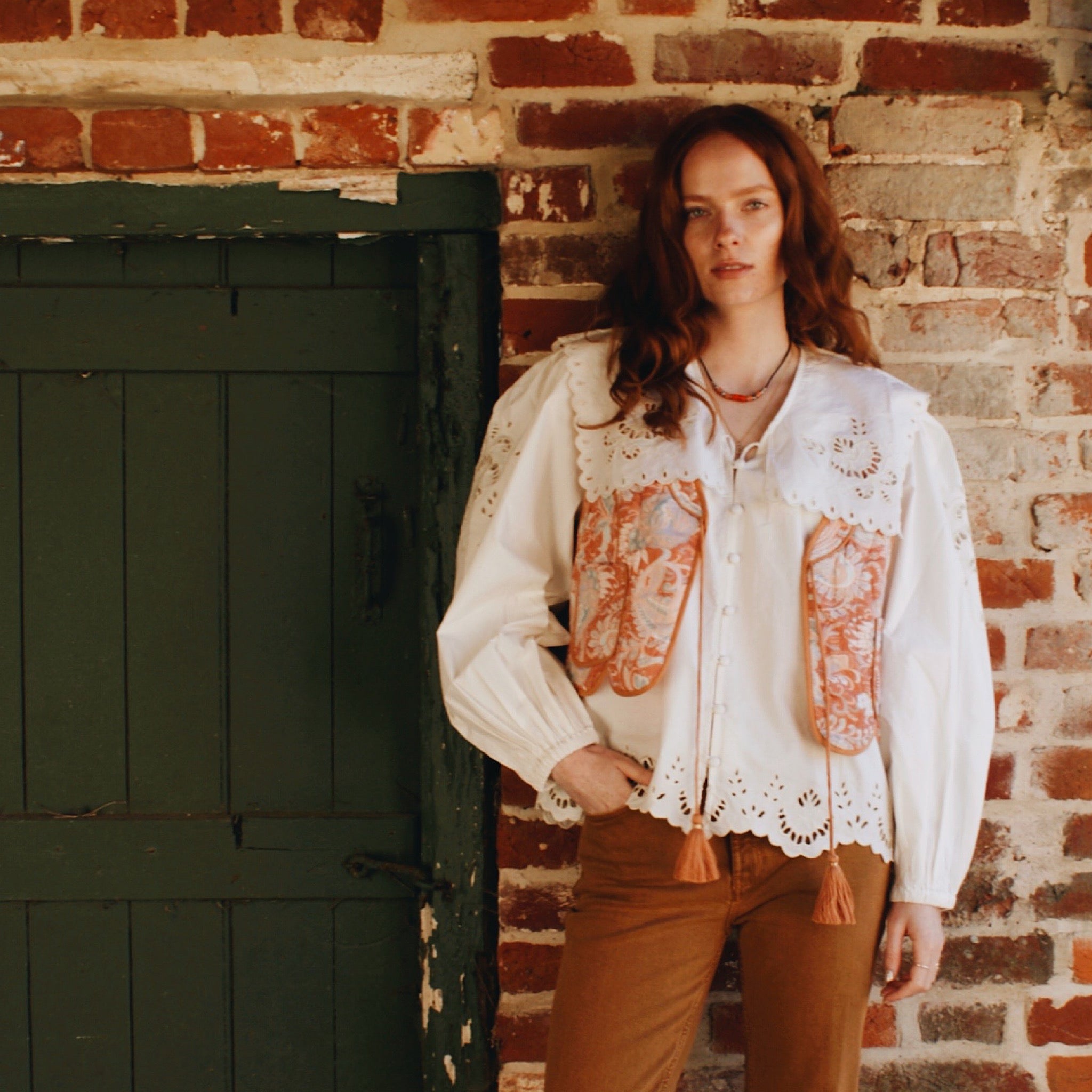Model styling a white long sleeve blouse with an oversized collar and embroidery details.