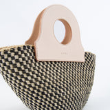 Close-up of natural basket bag with detailed weave, upcycled leather handbag