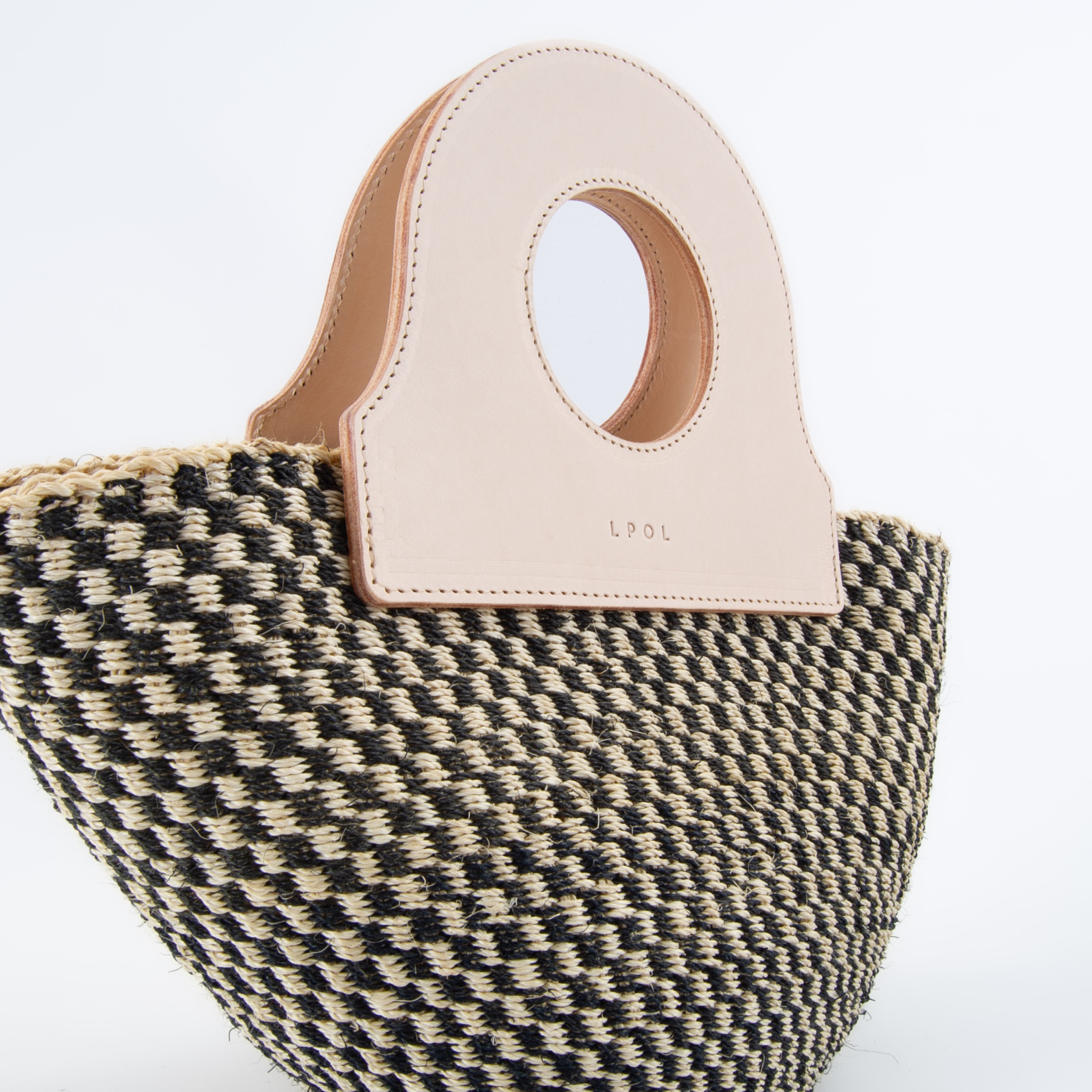 Close-up of natural basket bag with detailed weave, upcycled leather handbag