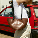 Brown leather handbag with buckle detailing, made from sustainable upcycled leather