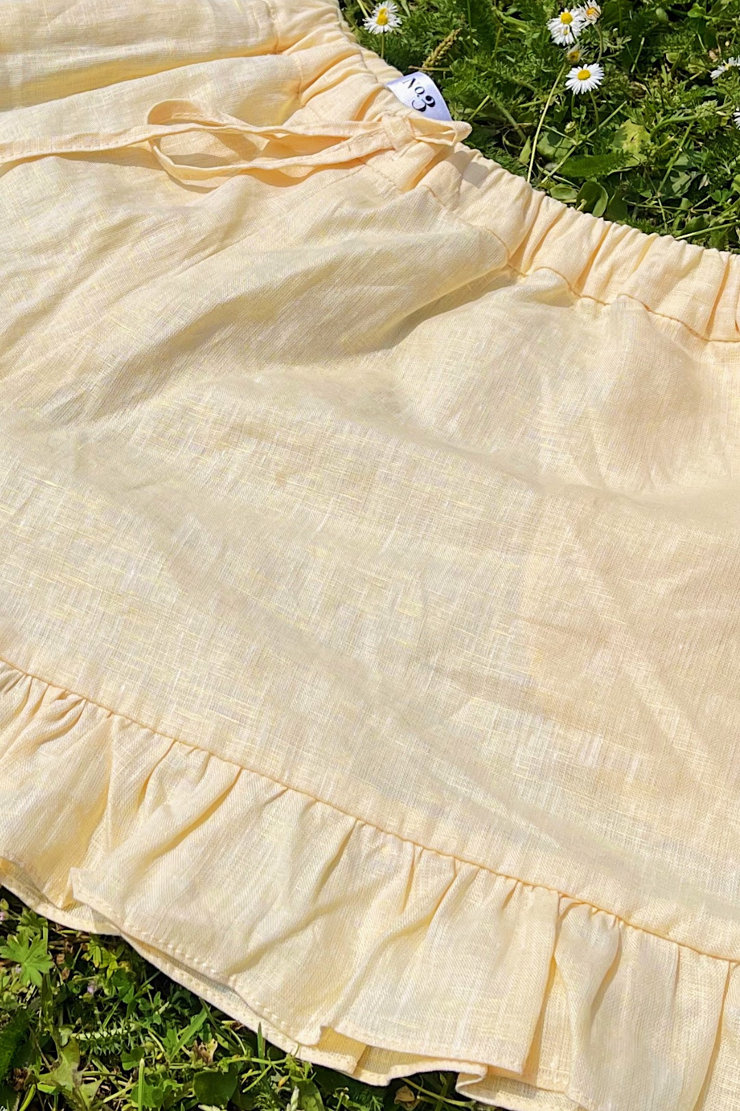 Short sleeve button up linen shirt with frill sleeves paired with high waisted linen shorts.