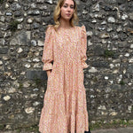 Ethical fashion – Model in The Grace Dress, featuring a tiered skirt, puff sleeves, and frill cuffs, made from sustainable deadstock cotton.