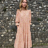 Ethical fashion – Model in The Grace Dress, featuring a tiered skirt, puff sleeves, and frill cuffs, made from sustainable deadstock cotton.