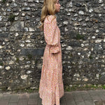 Side view of model in The Grace Dress – eco-friendly midi dress with a flowing tiered skirt and flattering bodice.