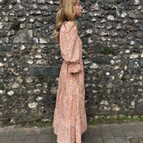 Side view of model in The Grace Dress – eco-friendly midi dress with a flowing tiered skirt and flattering bodice.