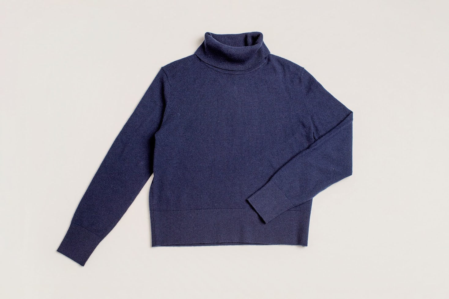 Close-up of fine knit admiralty navy turtleneck jumper with cropped fit