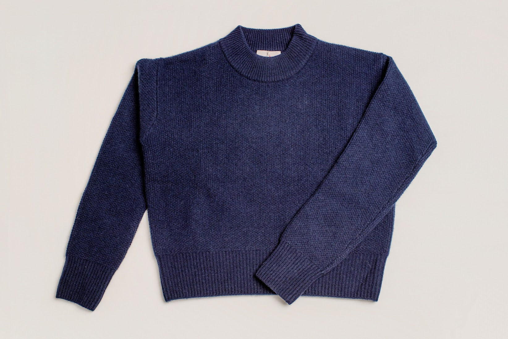 Close-up of chunky knit navy roll neck cropped jumper in soft wool cashmere