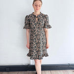 Front view of sustainable floral mini dress with ruffle hem, crafted in the UK.