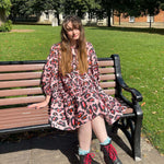 women wearing pink leopard dress sat on bench