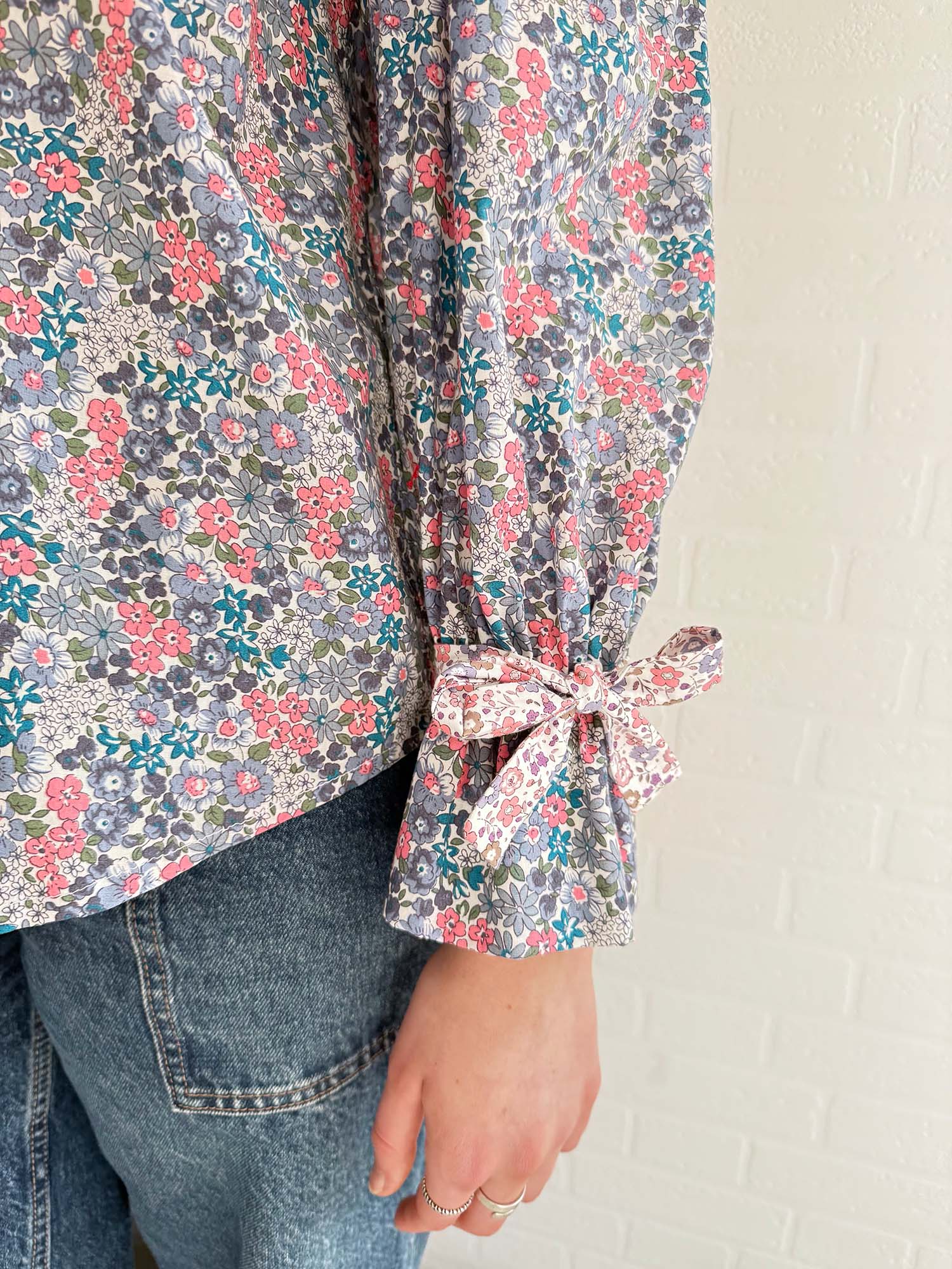 Slow fashion in action – model wearing feminine floral blouse with vintage buttons