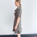 Side view of sustainable floral mini dress with ruffle hem, crafted in the UK.