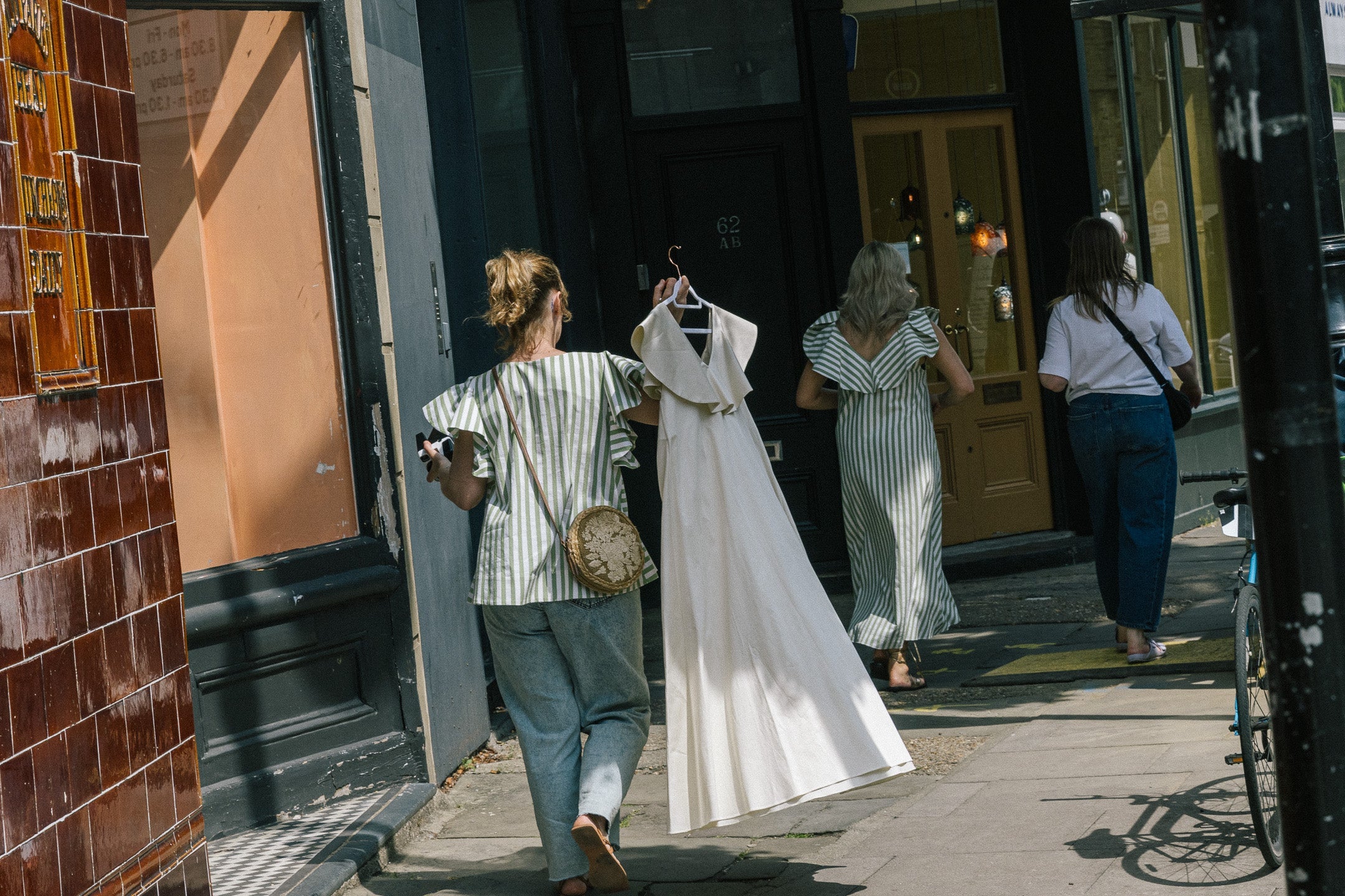 Model wearing a high neck blouse with ruffle sleeves and button up cotton shirt.