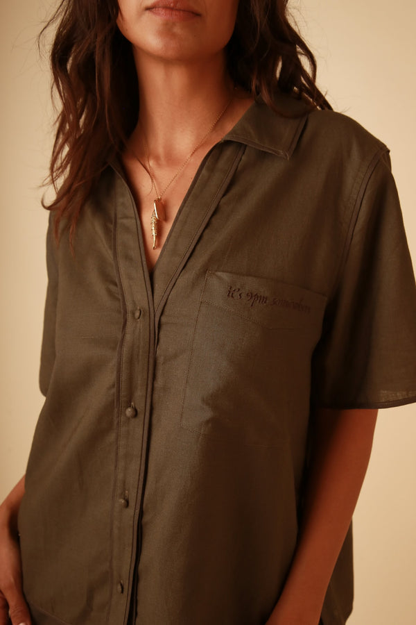 Stylish linen button down shirt with short sleeves paired with high waisted shorts in a matching set.