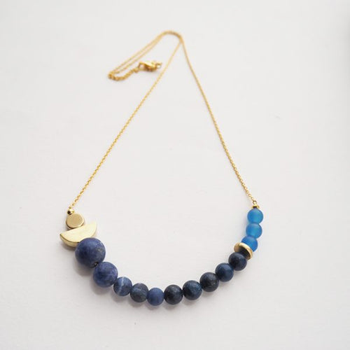Veering into new waters with the atoll necklace, this piece is made up of blue beads as well as the signature brass, by Percy Langley