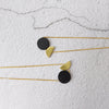 A fun geometric combination made up of a black solid circle and a brass semi circle, this is a necklace beautiful in it's simple shape, by Percy Langley