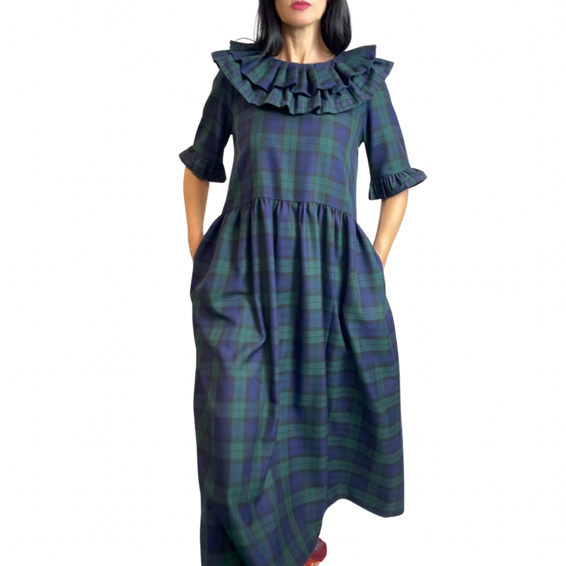 The black watch tartan, wide, double frill neck dress, has a fitted waist and statement frilled edge sleeves.  The dress is an easy-to-wear statement piece, that is handmade to order in Minkie London's Camden studio.