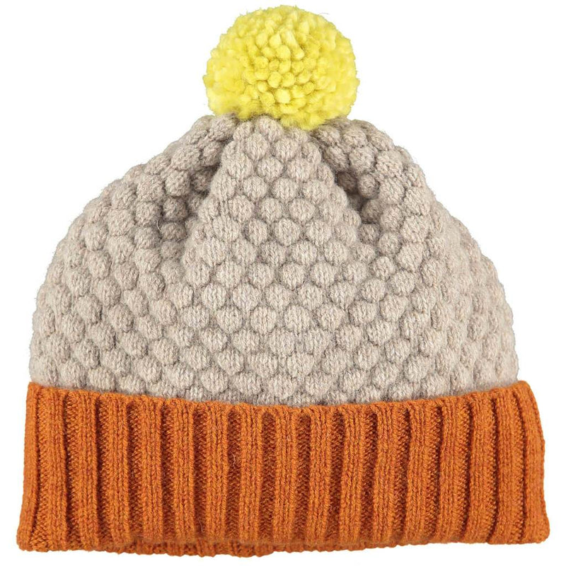 100% lambswool, handmade, children's bobble hat by Catherine Tough. Beautifully textured in honeycomb and rib knit with cute contrasting colour palette. Knitted in a traditional Scottish mill and hand-finished at their Hackney studio.
