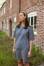 Comfortable cotton gingham check dress perfect for summer. The Gunnera Dress by Kate Sheridan is an effortless and versatile wardrobe staple. Featuring puff sleeves, side pockets and a loop button fastening at the back. 100% cotton, made in the North of England by Kate Sheridan.