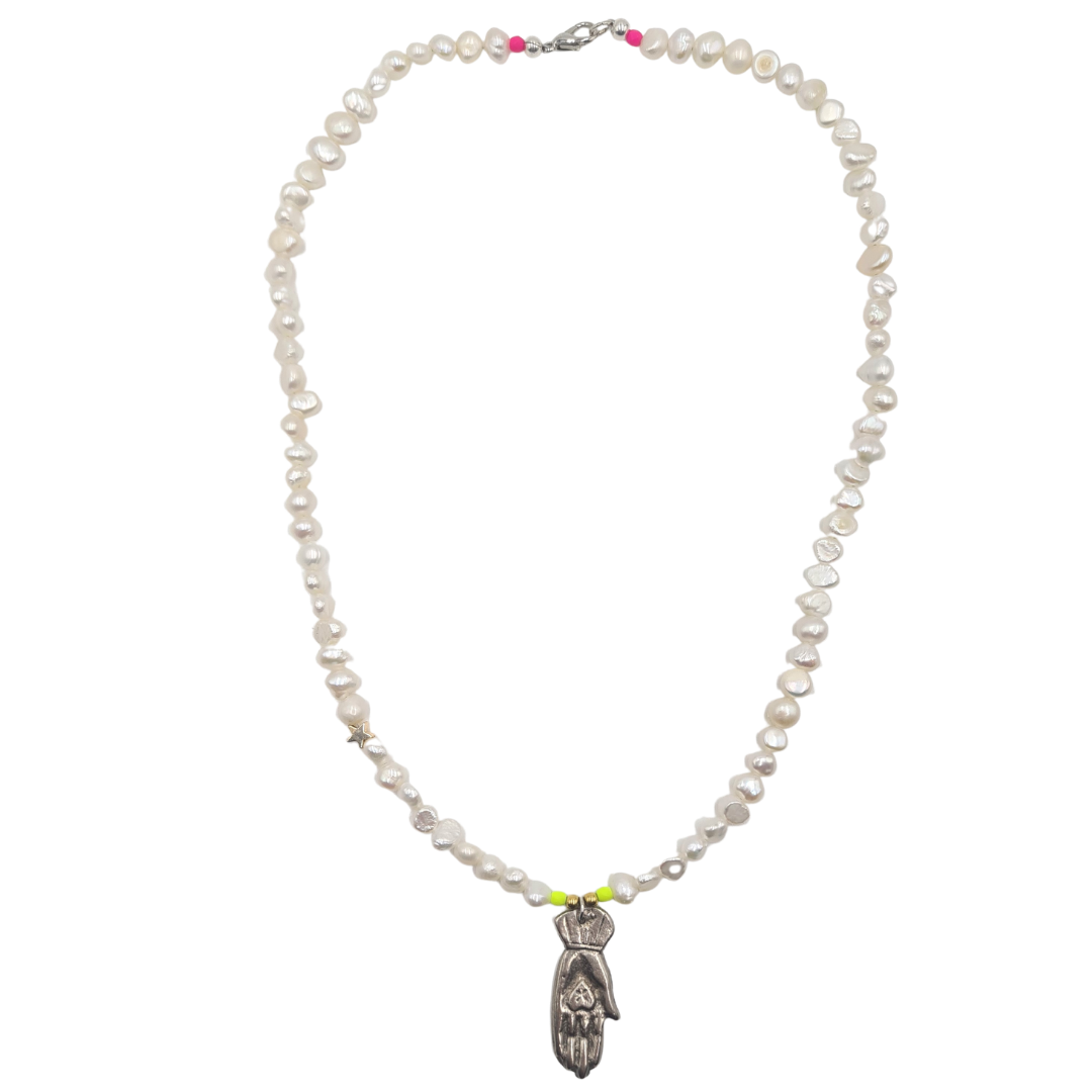 The Pearl Hand of Charity necklace by Bella Riley. Exclusive to Percy Langley.  Handmade in Hackney by jeweller Bella Riley, maker of joyful Demi-fine jewellery. Bella’s designs beautifully balance classic and edgy.  A string of freshwater nugget pearls with 18k gold-plated star and silver hand of charity pendant which symbolises giving with love.