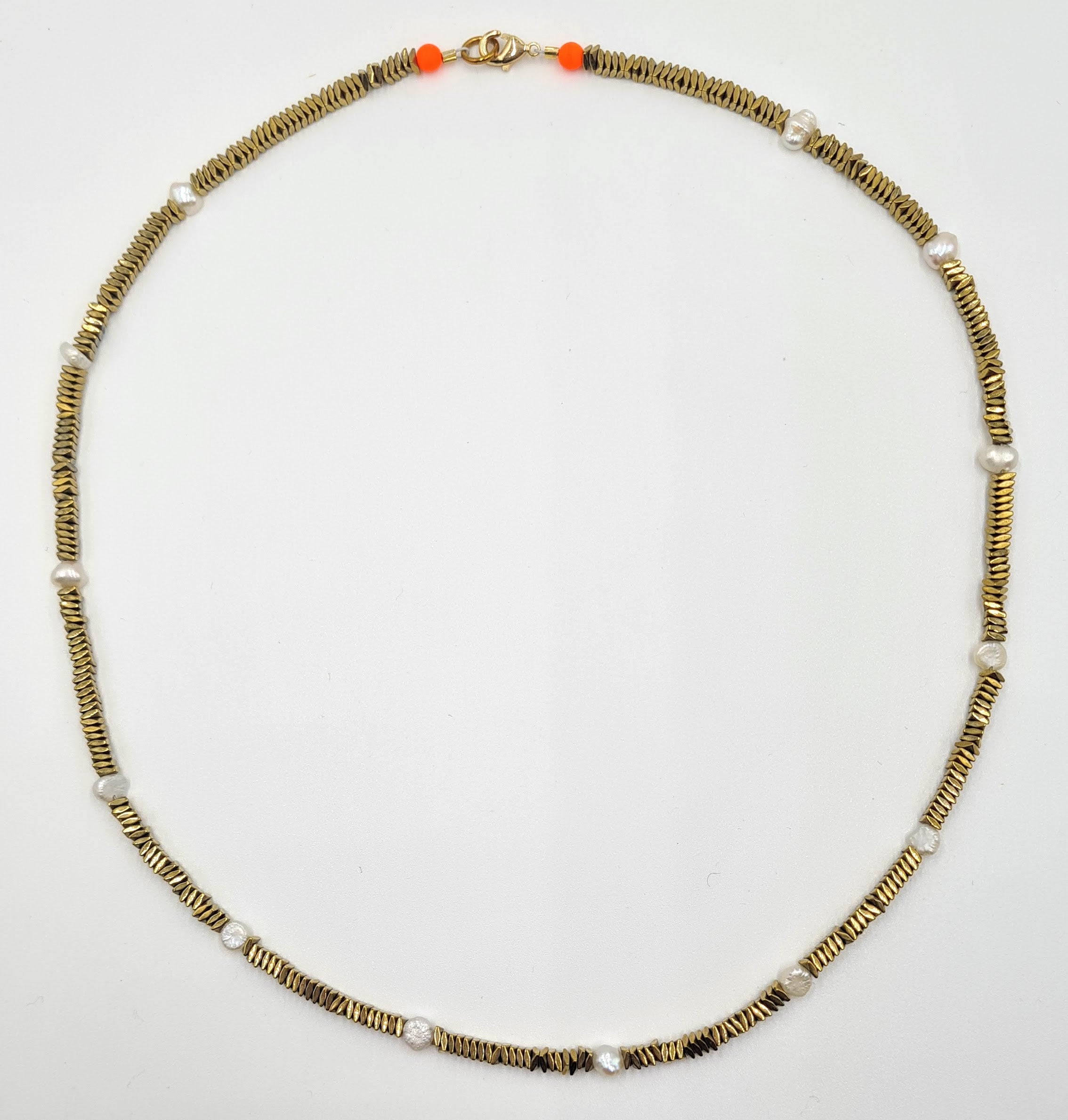 The Gold Hematite & Pearl Spacer necklace by Bella Riley. Exclusive to Percy Langley. Handmade in Hackney by jeweller Bella Riley, maker of joyful Demi-fine jewellery. Bella’s designs beautifully balance classic and edgy. Gold hematite beads with freshwater nugget pearl spacers. Shimmers and move beautifully replicating a traditional gold chain. Finished with gold-plated clasp lined with the signature Bella Riley neon glass beads.