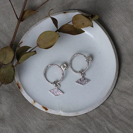 Textured shape earrings with a rhombus tag made out of recycled silver by April March Jewellery, sold by Percy Langley