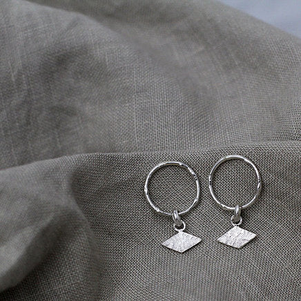 Textured shape earrings with a rhombus tag made out of recycled silver by April March Jewellery, sold by Percy Langley
