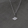 Textured shapes necklace with a rhombus tag made out of recycled silver by April March Jewellery, sold by Percy Langley