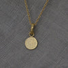 Textured shaped necklace with a round tag made out of fairmined gold vermeil by April March Jewellery, sold by Percy Langley