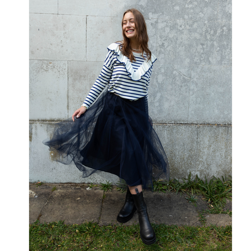 The Ambrey navy blue tulle skirt is a dreamy fairy tale like skirt that's surprisingly easy to wear and guaranteed to evoke joy in the wearer.   The tulle forms double layers on top of a cool cotton lining. The skirt is has an elastic waist band, making it very comfortable to wear.  Cut to fall below the knee with tulle side seems left open for extra swish.